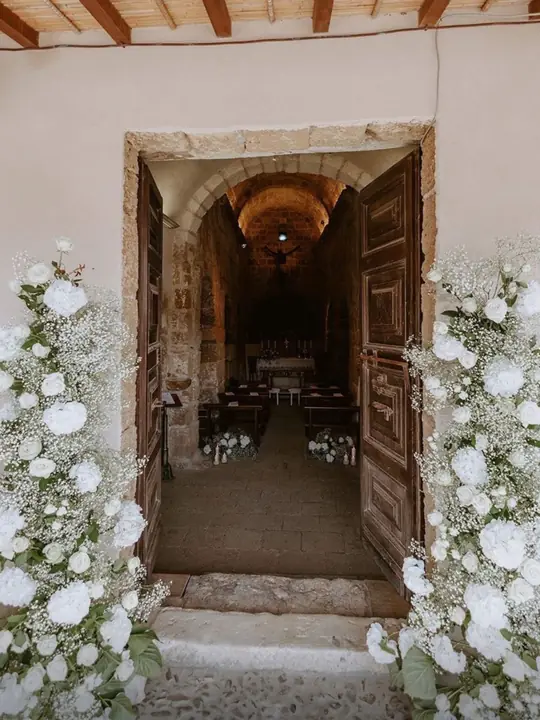 Allestimento floreale ingresso chiesa con composizioni bianche, matrimonio Sud Sardegna