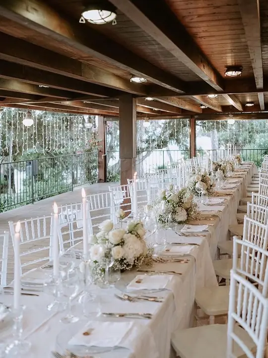 Tavolo del ricevimento allestito con composizioni floreali bianche, matrimonio Sud Sardegna